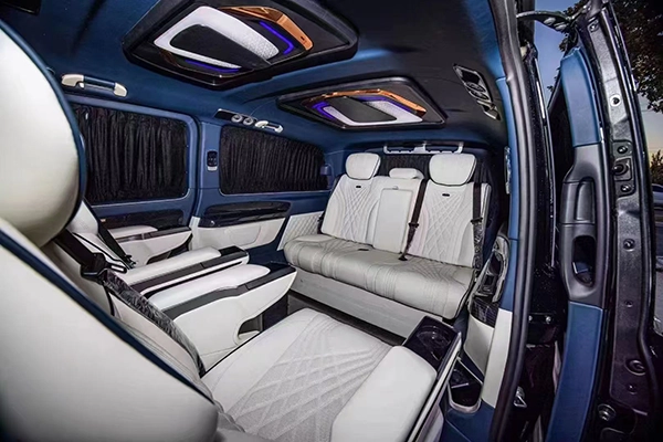 Quilted white leather car rear seat fitted inside blue MPV, matching front captain seats full cabin refit