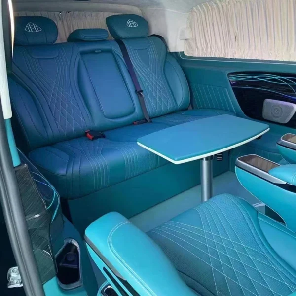 Full interior shot of back seat of car after installation, matching teal leather with folding side table for van