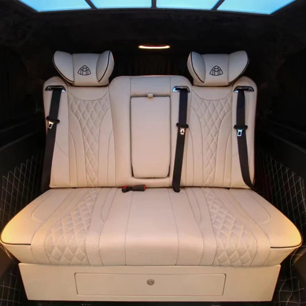 On-board installation photo of beige leather 3-seater car sofa bed with diamond stitching, embroidered headrests and pull-down middle armrest