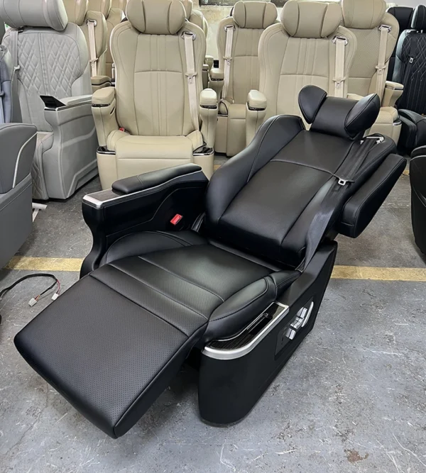 Black custom luxury car seat in fully reclined position with leg rest extended for maximum comfort