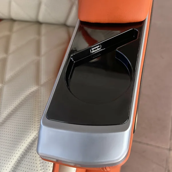 Close-up of a luxury car seat armrest featuring a built-in USB charging port and a sleek storage compartment.