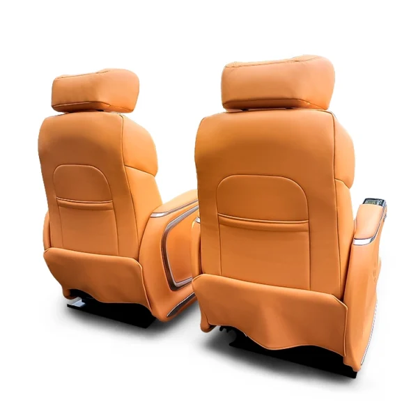 Rear view of premium orange second row captain seats featuring a clean leather finish and integrated storage pockets for luxury van interiors.