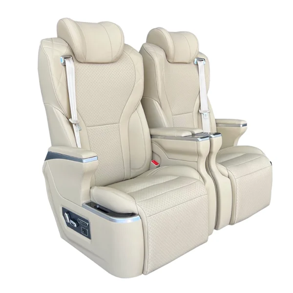 A pair of luxury VIP captain seats in beige leather, showcasing the side control panel, integrated seatbelts, and premium diamond-stitch detailing.