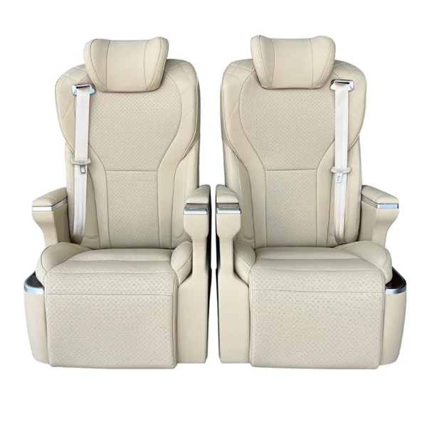 A pair of luxury VIP captain seats in beige Nappa leather, featuring a front-facing symmetrical design with integrated seatbelts and adjustable leg rests.