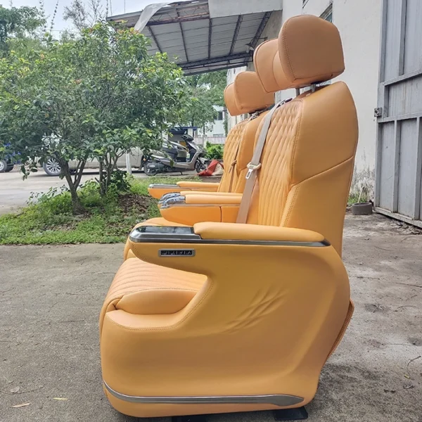 Side view of premium orange second row captain seats showing ergonomic design and sleek armrests for luxury van interiors.