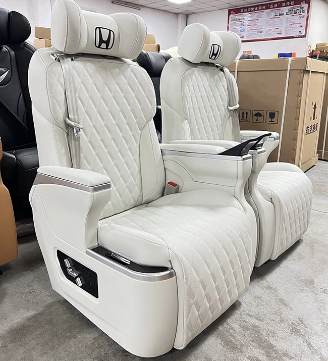 Workshop shot of dual white quilted Sienta captain seats fitted with new physical key control panel