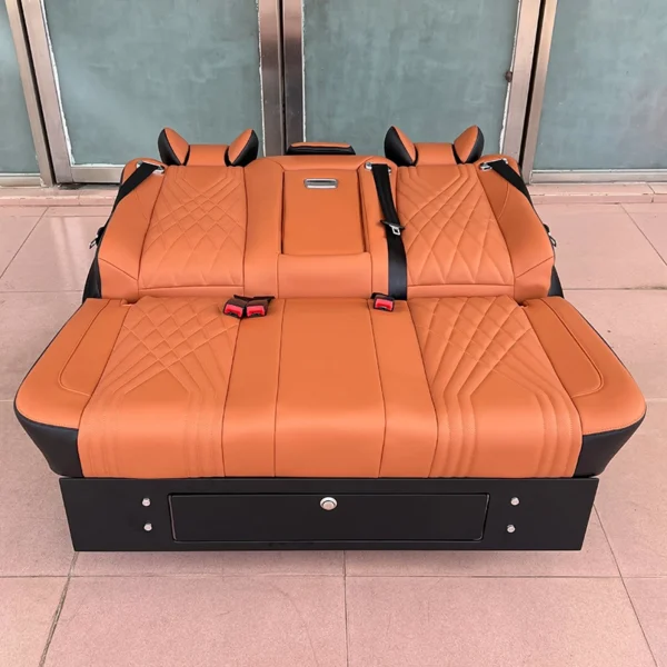 Full flat laid-down shot of orange leather 3-seater van seat bed with diamond stitching, central foldable armrest and bottom storage drawer
