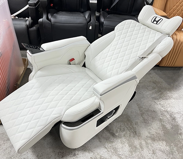 Overlook shot of white quilted Sienta captain seat laid fully flat with extended leg rest