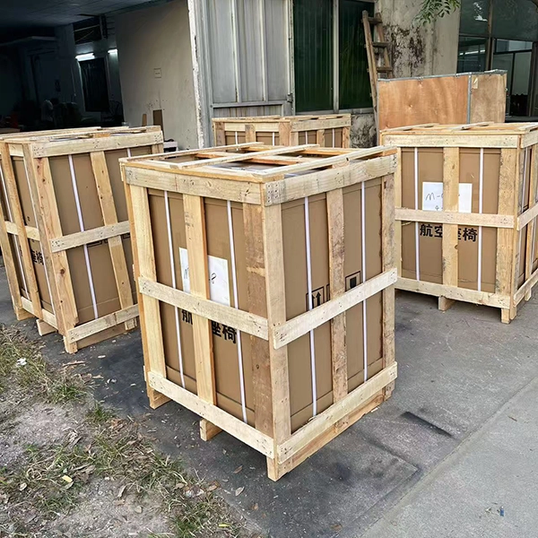 Open slat wooden frame packaging for auto captain seats, lined with carton and marked shipping labels for air transport