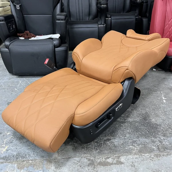 Orange perforated leather auto electric seat fully laid flat at 180°, with side physical adjustment control buttons